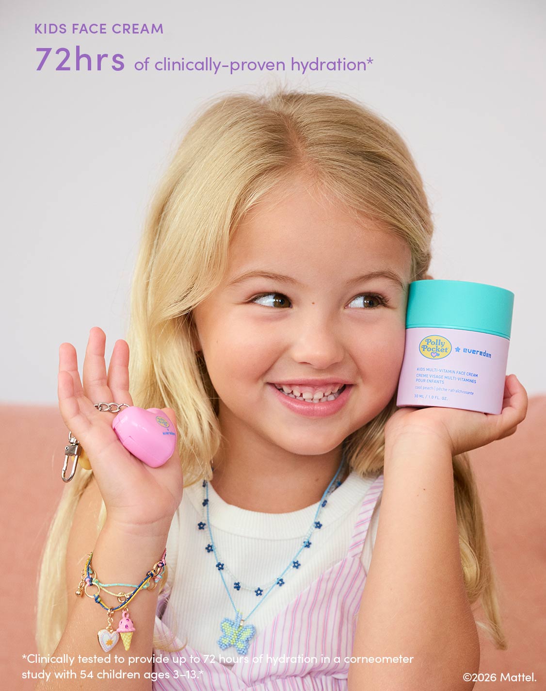 Kids Face Cream: 72 hours of clinically-proven hydration, clinically tested to provide up to 72 hours of hydration in a corneometer study with 54 children ages 3–13. Smiling child holding the Polly Pocket™ × Evereden Kids Multi-Vitamin Face Cream and heart-shaped lip balm.